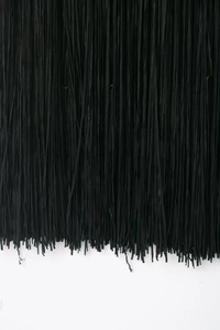Close-up detail of high-quality dense black fringe tassels on a designer bandage dress