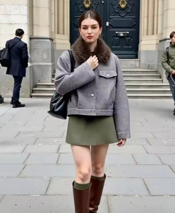 Détail d'une veste courte grise avec col en fausse fourrure brune et texture laineuse