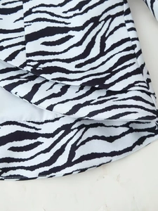 Détail macro du tissu à imprimé zèbre avec ourlet asymétrique et doublure blanche
