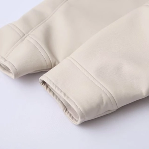 Close-up of cream white faux leather jacket sleeve showing fine texture and neat stitching