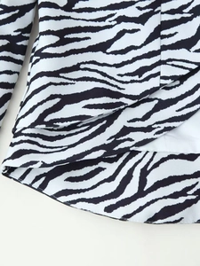 Détail de l'ourlet de veste imprimé zèbre montrant le design superposé et la texture