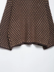 Detailed view of the brown geometric jacquard knit texture on a loose long sleeve cardigan