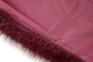 Macro detail showing the burgundy faux fur texture and smooth inner lining of the vest