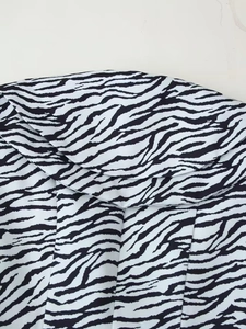 Détail du tissu à imprimé zèbre avec des couches de volants élégantes en noir et blanc
