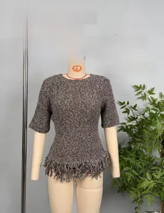 Detailed view of women's grey knit short sleeve top with dense fringe hem detail