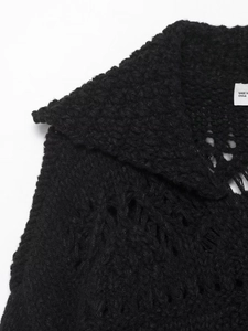 Detail of loose hollow knit texture and turn-down collar on black chunky knit cardigan