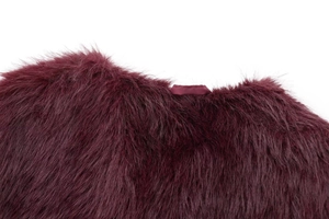 Detail shot of plush dark red faux fur vest featuring soft texture and satin ribbon loop
