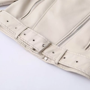 Detail of faux leather moto jacket with metal buckles, eyelets and silver zippers