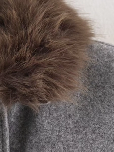 Gros plan sur la veste d'hiver en laine grise épaisse avec bordure en fourrure marron douce
