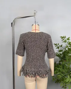 Detail shot of brown knit top with classic cable pattern and elegant fringe hem