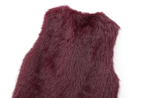 Detail view of burgundy faux fur vest with long fluffy texture and round neckline