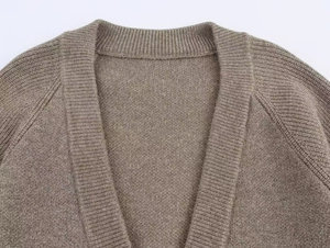 Gros plan détaillé du cardigan en maille marron avec fil métallique et texture du col en V