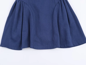Détail de l'ourlet de la robe trapèze bleu marine avec des plis et des coutures soignées