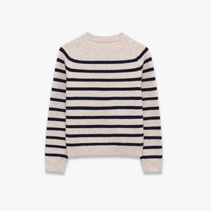 Close-up of the ribbed neckline and striped knit texture of the sweater