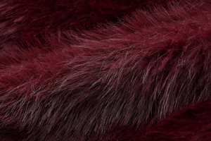 Detailed close-up of dark burgundy faux fur texture with a luxurious metallic sheen