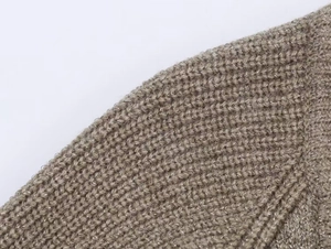 Détail macro du manteau en tricot taupe montrant le fil métallique étincelant et la maille