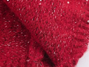 Macro shot of red knit fabric with mohair texture and shimmering metallic silver threads