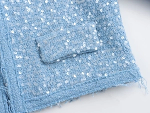 Detail of light blue sequined tweed jacket showing pocket with frayed edges