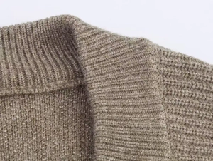 Détail d'un cardigan en maille avec fil pailleté métallique et encolure en V côtelée