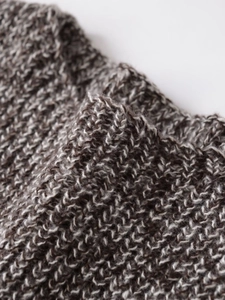 Close-up of thick chunky knit fabric in dark brown and beige mixed yarn texture