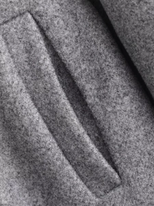 Gros plan sur la texture du tissu en laine grise et les coutures de la poche de veste