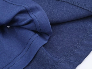 Gros plan détaillé du tissu tricoté bleu marine avec couture plate et ourlet précis