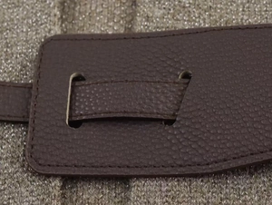Vue détaillée de la texture du cuir café avec des coutures fines sur tricot métallique