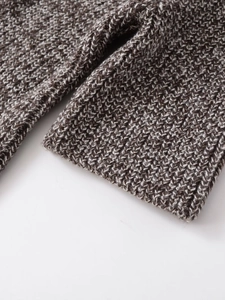 Close-up of mixed-color thick knit texture and fringe detail on the short sleeve sweater