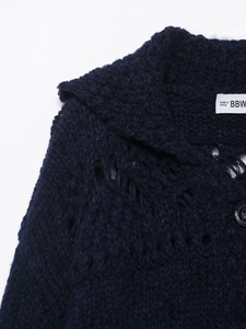Detail of navy knit cardigan showing intricate openwork crochet and textured collar label