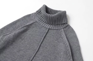 Detail of grey high-neck knit sweater with raglan sleeves and decorative stitching seams