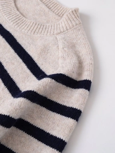 Close-up of the fine knit texture and striped pattern on this beige and navy sweater