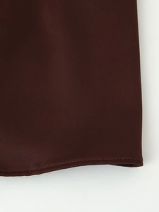 Detail of chocolate satin fabric edge with high-quality stitching and smooth glossy finish