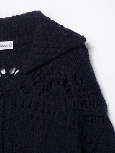 Detail of navy blue open knit cardigan collar with size label and hollow texture