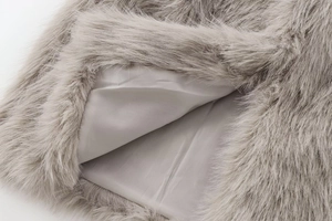Detailed close-up of soft grey faux fur texture and smooth inner lining of the vest