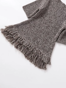 Detailed close-up of thick knit gray texture and dense fringe trim on the hemline