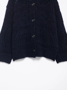 Detail of navy blue chunky knit cardigan with hollow textures and dark round buttons