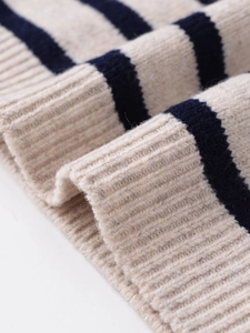 Close-up of beige and navy striped knit fabric showing rib-knit texture and soft wool material