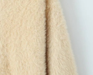 Nahaufnahme von weichem Mohair-Strickgewebe mit flauschiger Textur und beigen Fasern
