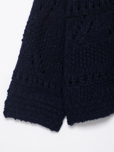 Detail of dark blue chunky knit cardigan showing hollow out crochet texture and wool fabric