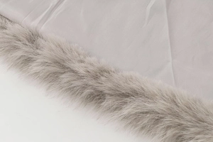 Close-up of light gray faux fur trim and synthetic twill fabric on fashion vest