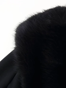 Close-up of fluffy black faux fur collar texture on a winter wool coat with rich volume
