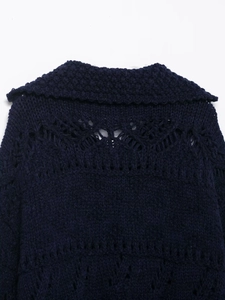 Close-up detail of navy blue hollow-out crochet knit pattern on the cardigan back