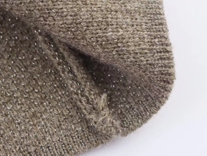 Gros plan sur un tissu en maille marron avec fils métalliques et texture côtelée