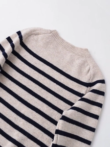 Close-up of the ribbed crew neck and soft knit texture of a striped wool blend sweater