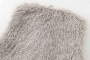 Close-up of soft grey faux fur texture on a stylish women's vest with fluffy fibers