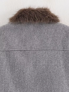 Détail d'un manteau gris en laine avec col en fourrure marron foncé et coutures au dos