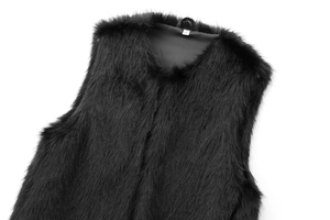Detailed view of black faux fur vest texture with smooth lining and size S label