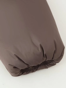Macro shot of dark brown puffer jacket elastic windproof cuffs with precision stitching