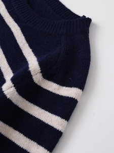 Detailed view of dark blue and off-white striped knit sweater showing neckline texture