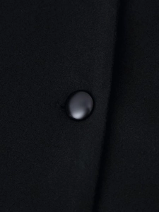 Detailed macro view of a glossy black dome button on premium textured wool fabric